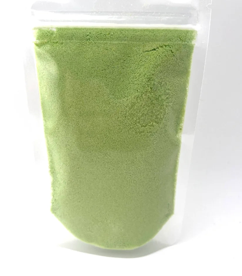 Green potion powder in a clear plastic pouch on a white background