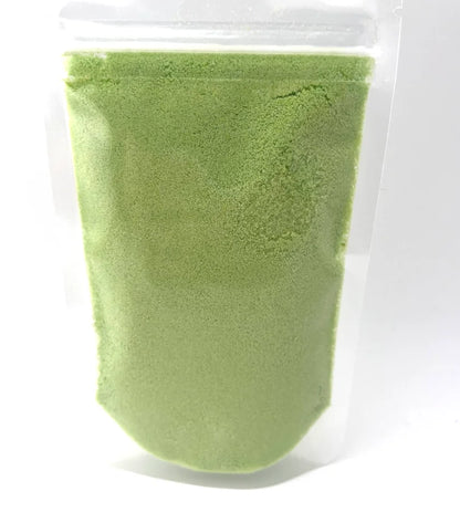 Green potion powder in a clear plastic pouch on a white background