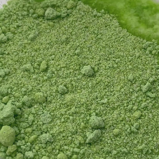 A video of green potion powder - water is dropped on and it fizzes and bubbles