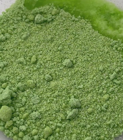 A video of green potion powder - water is dropped on and it fizzes and bubbles
